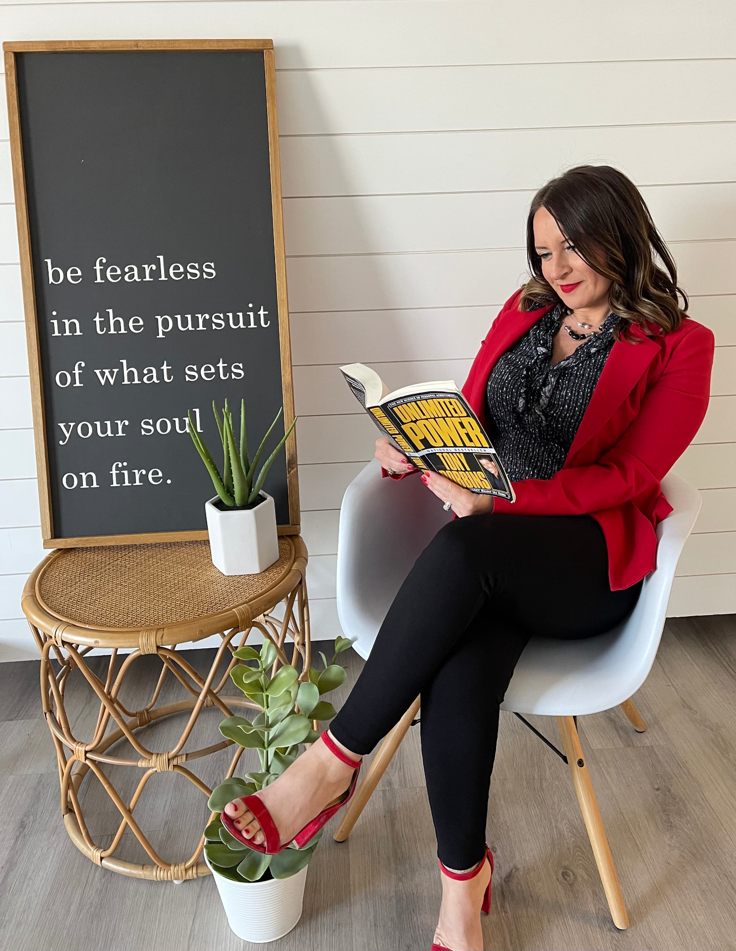 Tara Allen reading beside a chalkboard sign that reads be fearless in the pursuit of what sets your soul on fire